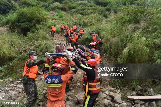 Fire and rescue personnel from Ganzi prefecture carry an injured elderly man off a mountain on a stretcher in Ziyachang village, Luding county,...