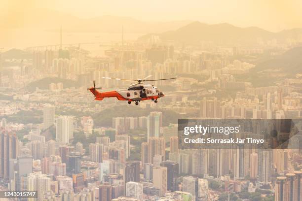 the rescue helicopter flying over the city of hong kong - hélicoptère ville photos et images de collection