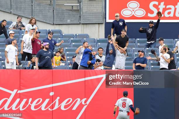 Fans reach for a home run ball hit by Aaron Judge of the New York Yankees during the game between the Minnesota Twins and the New York Yankees at...