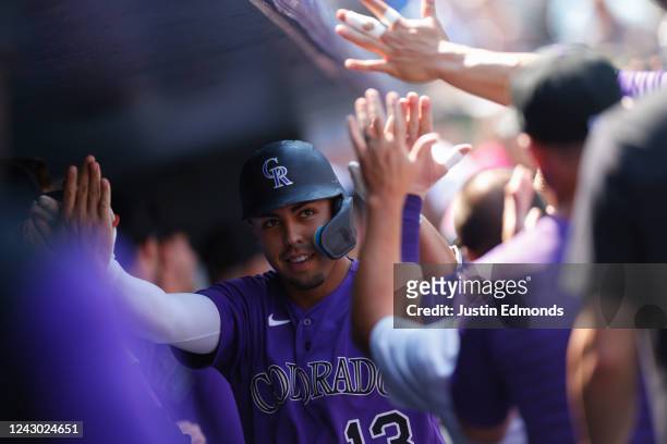 Alan Trejo of the Colorado Rockies celebrates in the dugout with teammates after hitting a two run home run in the second inning against the...