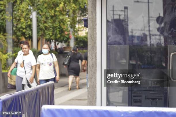 Pedestrians outside a government Chivo Bitcoin automated teller machine kiosk on the one-year anniversary of Bitcoin adoption in San Salvador, El...