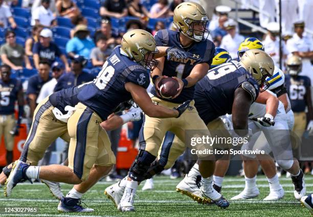 Navy Midshipmen quarterback Tai Lavatai hands off to fullback Logan Point during the University of Delaware fighting Blue Hens game versus the Naval...