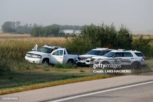 Royal Canadian Mounted Police vehicles are seen next to a pickup truck at the scene where suspect Myles Sanderson was arrested, along Highway 11 near...