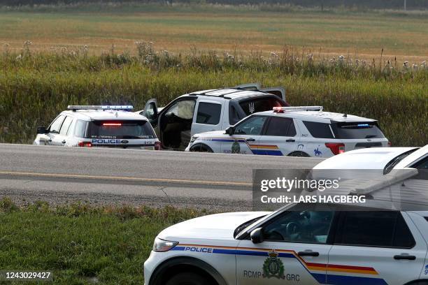 Royal Canadian Mounted Police vehicles are seen next to a pickup truck at the scene where suspect Myles Sanderson was arrested, along Highway 11 near...