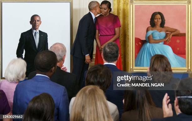 Former US President Barack Obama kisses former US First Lady Michelle Obama during a ceremony to unveil their official White House portraits, in the...