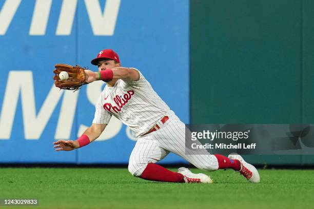 Kyle Schwarber of the Philadelphia Phillies makes a sliding catch one a ball hit by Miguel Rojas of the Miami Marlins in the top of the third inning...