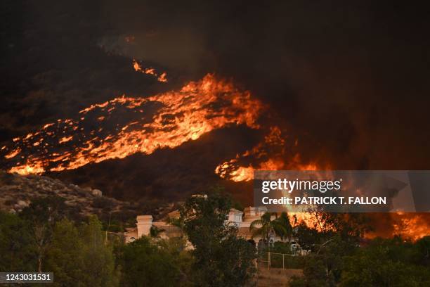 Plumes of smoke rise as wildfire approaches a home during the Fairview Fire near Hemet, California in Riverside County on September 7, 2022. - A...