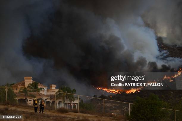 Plumes of smoke rise as wildfire approaches a home during the Fairview Fire near Hemet, California in Riverside County on September 7, 2022. - A...