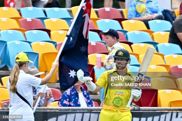 Australia's David Warner touches the national flag as he walks onto the ground to start the first innings during the second one-day international...