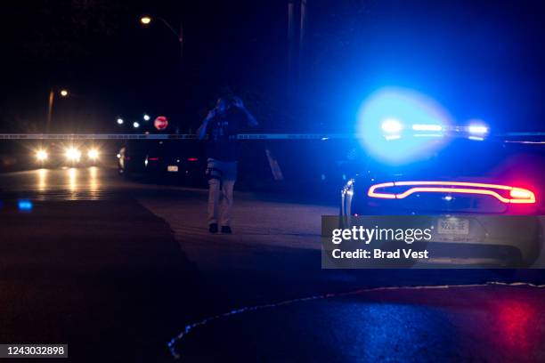 Police officer investigates at the scene where a man was taken into custody following a series of shootings throughout the city on September 7, 2022...