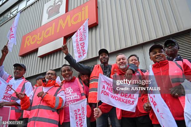 Royal Mail postal workers hold placards and chant slogans as they stand on a picket line outside a delivery office, in north London, on September 8,...