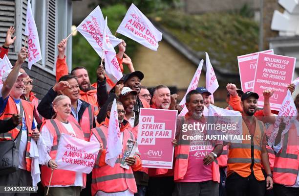 Royal Mail postal workers hold placards and chant slogans as they stand on a picket line outside a delivery office, in north London, on September 8,...