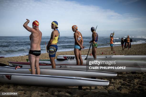 Participants stand next to their kayaks on a starting line as they take part in a national inshore rescue competition in Hossegor, southwestern...