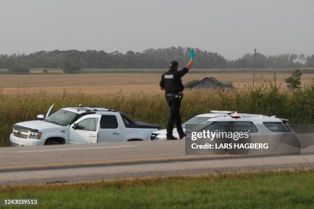 Royal Canadian Mounted Police officer inspects the scene where suspect Myles Sanderson was arrested, along Highway 11 near the town of Rosthern,...