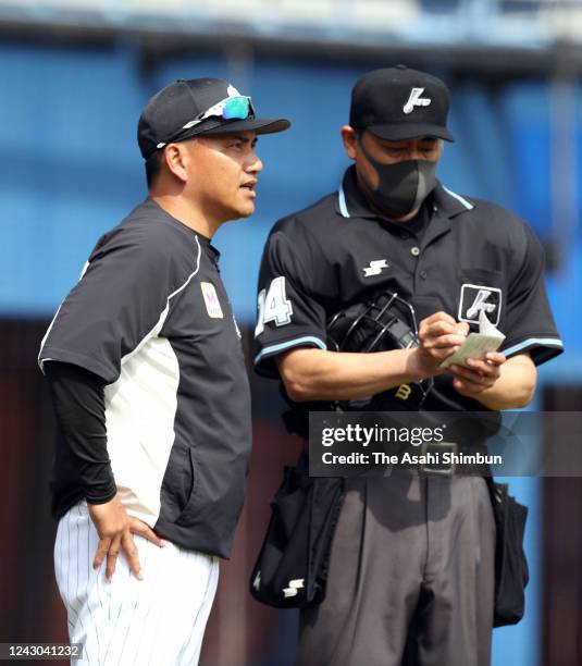 Head coach Tadahito Iguchi of the Chiba Lotte Marines calls for player changes to the plate umpire wearing a face mask during the practice game...