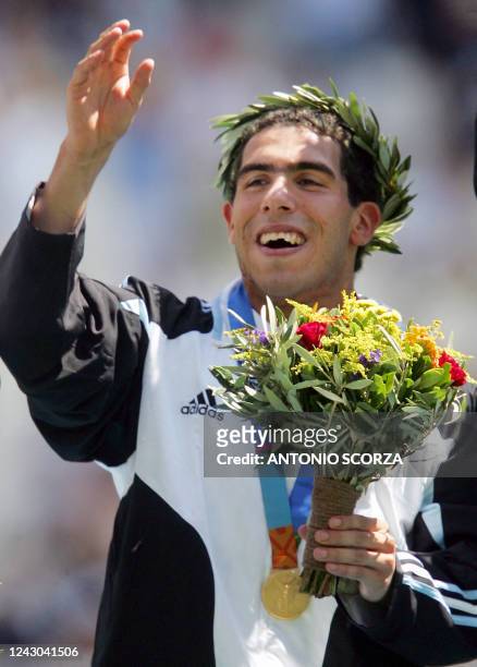 Argentine's national football team forward Carlos Tevez celebrates with his gold medal on the podium of the 2004 Olympic Games tournament at the...