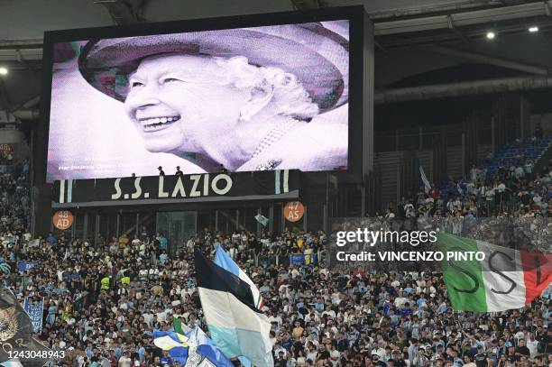 Portrait of Britain's Queen Elizabeth II is displayed on a giant screen following the announcement of her death, prior to the start of the UEFA...