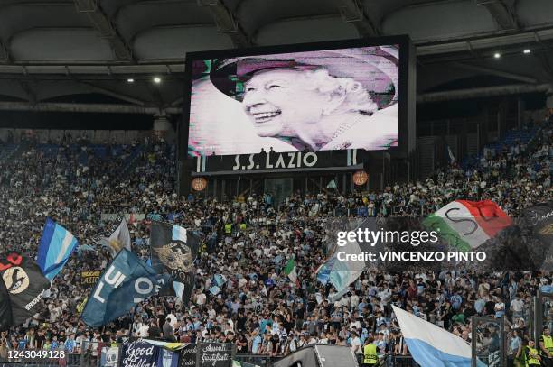 Portrait of Britain's Queen Elizabeth II is displayed on a giant screen following the announcement of her death, prior to the start of the UEFA...