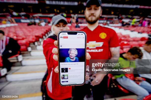 Manchester United fans with the news of the death of Queen Elizabeth II of England who passed away during the UEFA Europa League match between...