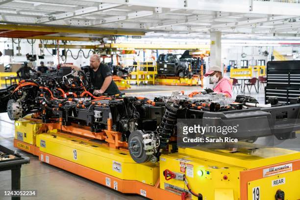Steve Hawley, left, and Yolanda Reed do inspections and repairs on Ford F-150 Lightning underbodies at Fords Rouge Electric Vehicle Center on...