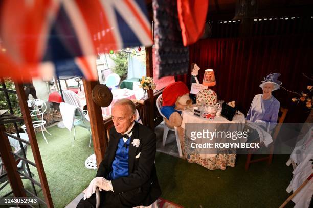 Owner Edmund Fry discusses the life of Queen Elizabeth II by a full size display of the Queen with Paddington Bear at his Rose Tree Cottage English...
