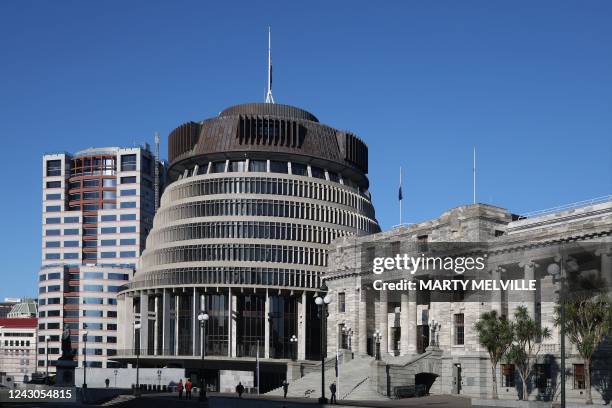 The New Zealand flags on the roof of Parliament buildings sit at half mast after the death of the Queen, in Wellington on September 9, 2022. - Queen...