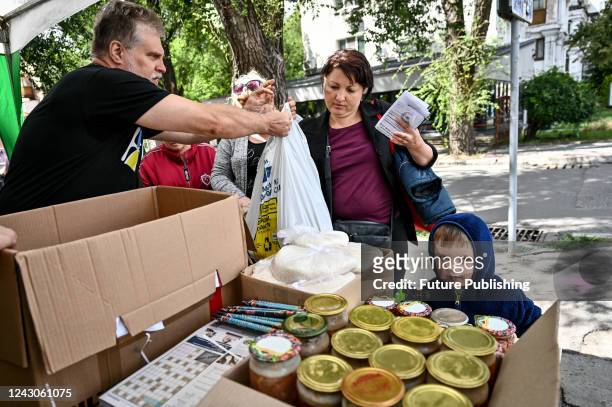 Volunteers distribute canned meat to IDPs at a distribution point for IDPs from Mariupol, Volnovakha and the temporarily occupied territories of the...