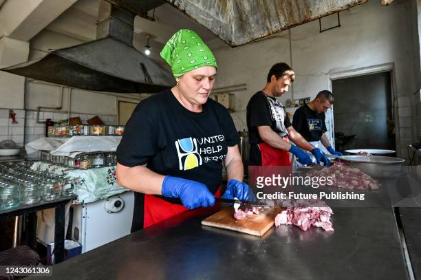 Volunters slice meat before canning, the product will be distributed to the military and IDPs, Zaporizhzhia, south-eastern Ukraine.