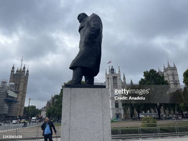 View of statue of Winston Churchill, the Queen's first Prime Minister, as people gather outside Buckingham palace following the announcement of the...