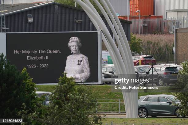 The motorcade of King Charles III passes a billboard tribute to Queen Elizabeth II as he arrives at Aberdeen Airport for his return to London on...