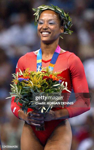 Silver medallist Annia Hatch celebrates on the podium after the women's vault final 22 August 2004 at the Olympic Indoor Hall in Athens during the...