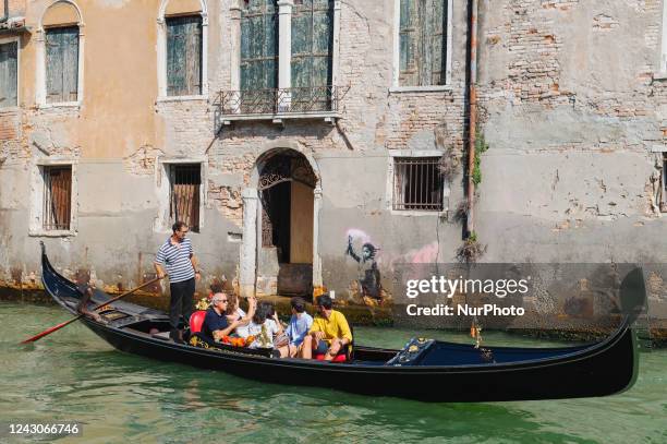 View of street artiste Banksy's work of a migrant child appears on the outer wall of a house overlooking the Rio Ca Fossari, made by the artist...