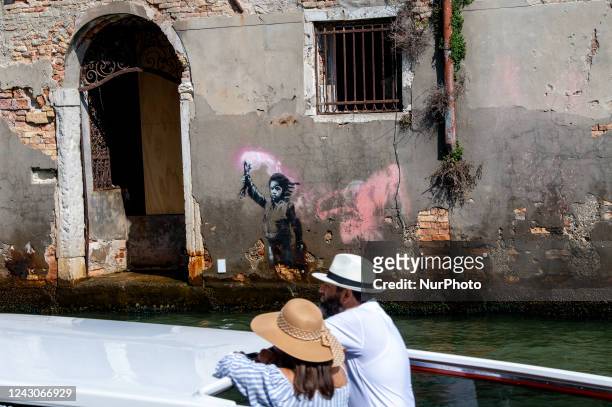 View of street artiste Banksy's work of a migrant child appears on the outer wall of a house overlooking the Rio Ca Fossari, made by the artist...