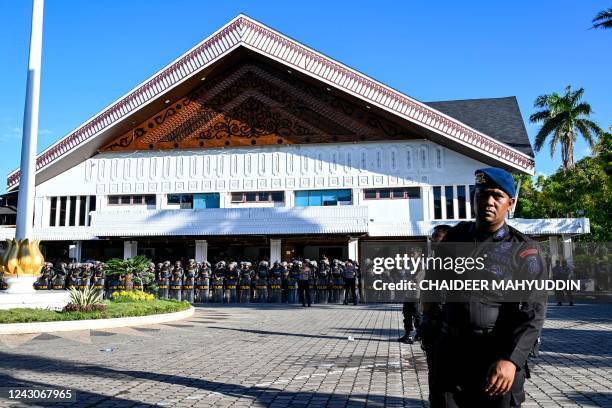 Policemen stand guard as university students protest against the recent price hike of gasoline in front of the People's Representative Council in...