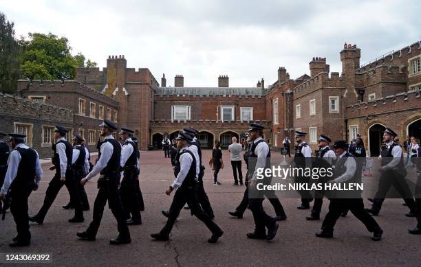 Police officers march past Friary Court at St James's Palace in London on September 9 a day after Queen Elizabeth II died at the age of 96. - Queen...