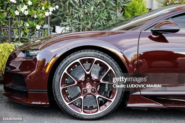 This photograph taken on September 8, 2022 shows a part of a Bugatti Chiron sports car parked in front of "Cafe de l'Esplanade", in Paris.