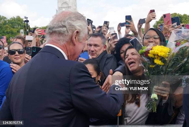 Britain's King Charles III and Britain's Camilla, Queen Consort greets the crowd upon arrival at Buckingham Palace in London, on September 9 a day...