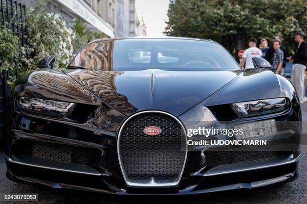 This photograph taken on September 8, 2022 shows the front of a Bugatti Chiron sports car parked in front of "Cafe de l'Esplanade", in Paris.