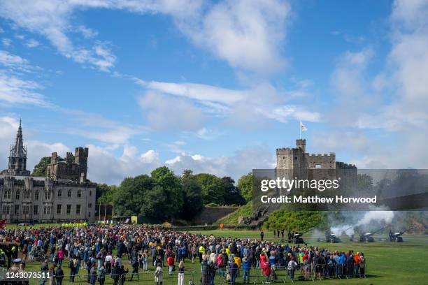 Mourners gather to watch a 96-gun salute at Cardiff Castle on September 9, 2022 in Cardiff, United Kingdom. Elizabeth Alexandra Mary Windsor was born...