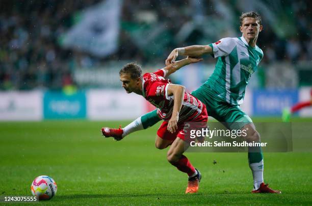 Robert Gumny of Augsburg fights for the ball with Mitchell Weiser of Bremen during the Bundesliga match between SV Werder Bremen and FC Augsburg at...