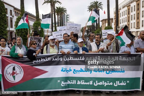 Moroccan demostrators lift banners against the normalisation of ties with Israel at a protest in Rabat on September 9 following media reports on...