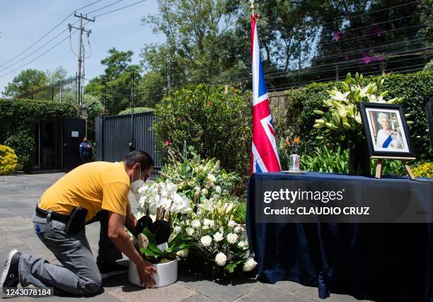 Visitor places flowers next to the condolences book and a portrait of the late Queen Elizabeth II at the British Residence in Mexico City on...