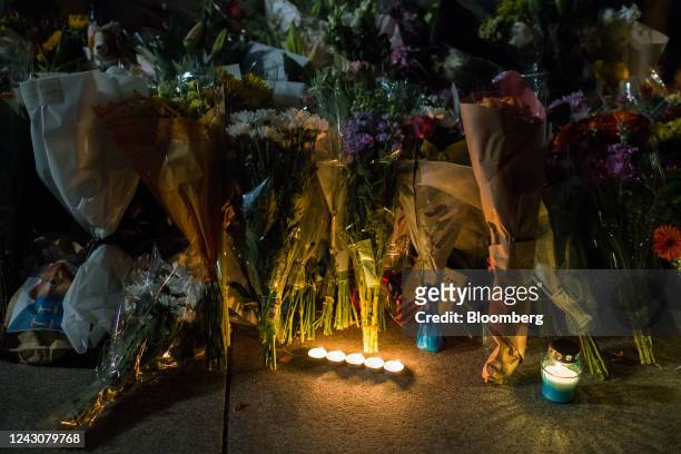 Floral tributes and candles outside Buckingham Palace on the first day of public mourning following the death of Queen Elizabeth II, in London, UK,...