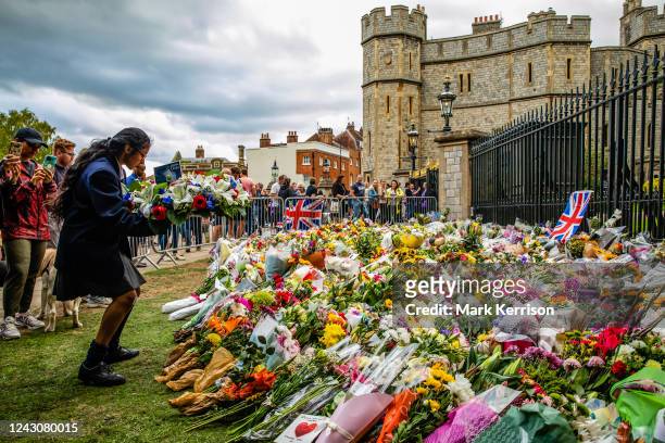Girl leaves a floral wreath on behalf of a school outside Cambridge Gate at Windsor Castle on 9th September 2022 in Windsor, United Kingdom. Queen...