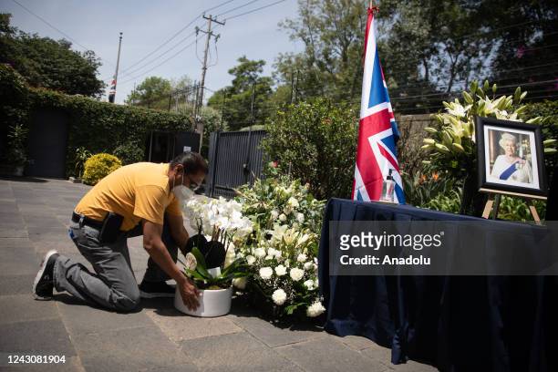 Man places flowers next to the condolences book and the portrait of the Queen Elizabeth II, at the British Residence, in Mexico City, Mexico on...