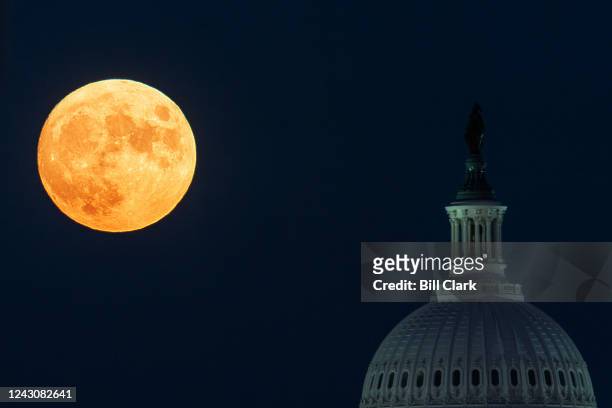 The Harvest Moon rises over the U.S. Capitol dome in Washington on Friday, September 9, 2022.