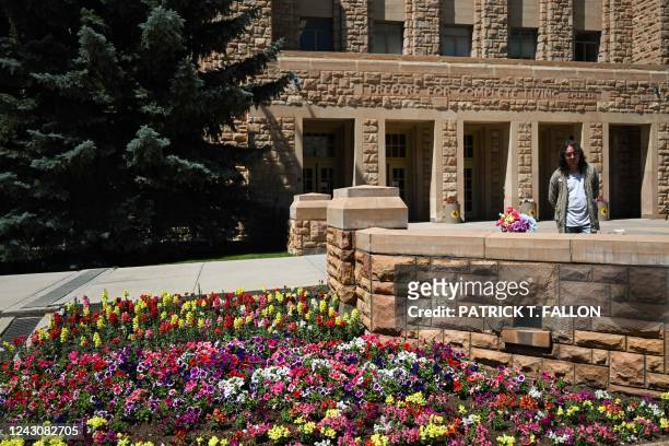 Laramie Pridefest Board Member, Tyler Wolfgang, looks at flowers on the Matthew Shepard Memorial Bench in memory of Shepard, a gay student who in...