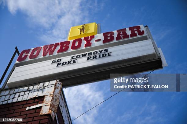 Sign reads "Go Cowboys" and "Poke Pride" outside the Cowboy Bar in downtown Laramie, Wyoming on August 13, 2022. Nearly 25 years ago, the brutal...