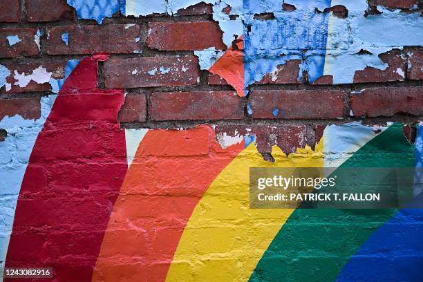 The paint of a rainbow peels off a brick wall in downtown Laramie, Wyoming on August 13, 2022. - Nearly 25 years ago, the brutal murder of Matthew...