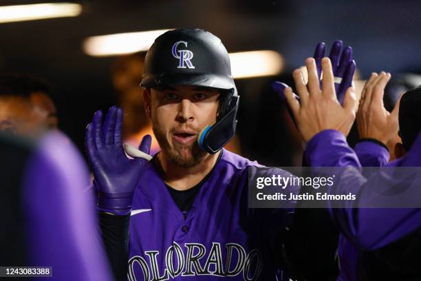 Cron of the Colorado Rockies is congratulated in the dugout after hitting a solo home run in the fourth inning against the Arizona Diamondbacks at...